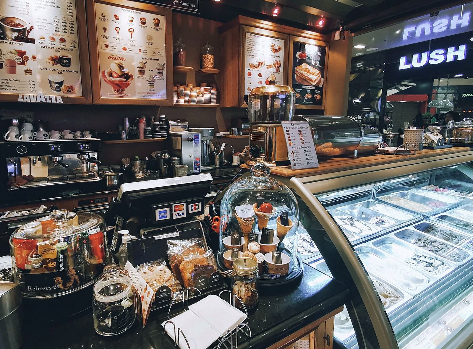 Warm and inviting café interior featuring an enticing dessert display and coffee station.